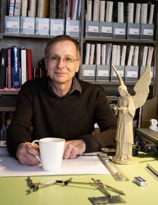Allan Stichbury in his office, with a model of the angel seen in Summer and Smoke